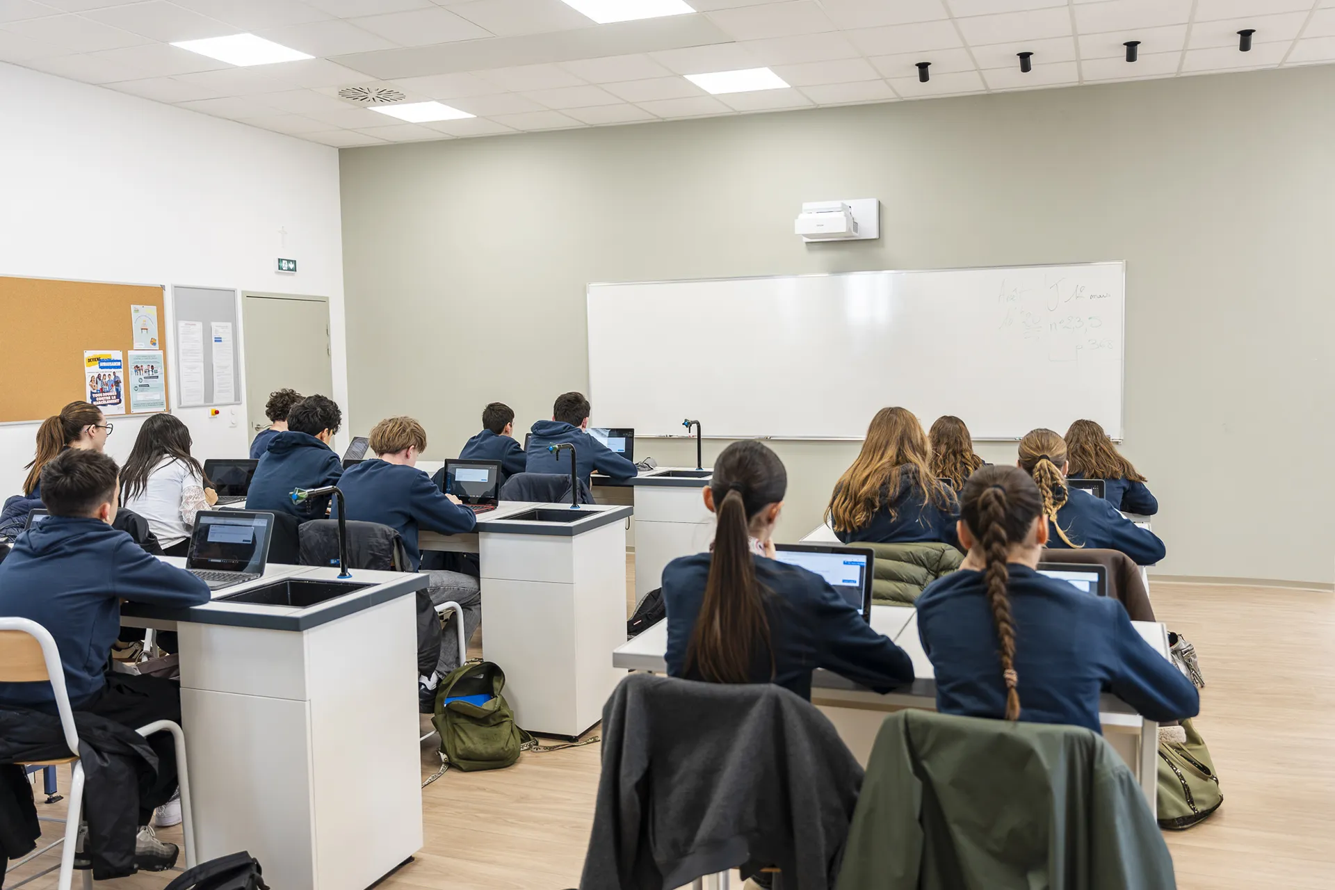 Salle de classe numérique du collège Pic La Salle à Béziers, élèves en cours avec ordinateurs portables dans un environnement moderne et bienveillant